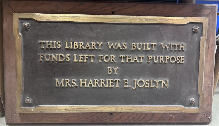 A photo of a plaque from the first library building on Noyes Blvd. It says This Library was built with funds left for that purpose by Mrs. Harriet E Josyln.